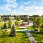 Rendering of the central community park at Mirra Towns featuring a children's playground, gazebo, paved walking paths, and landscaped green space surrounded by modern townhomes.
