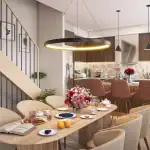 Architectural rendering of a modern open-concept kitchen and dining room at Riverbank Place, featuring a wood-slat dining table, circular pendant lighting, and a contemporary kitchen with dark wood cabinetry and a marble backsplash.