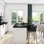 Luxury kitchen design at Sol Stacked Towns showcasing white cabinetry, black marble countertops, a central kitchen island with seating, and a bright dining area leading to an outdoor terrace.