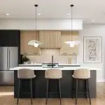 Modern open-concept kitchen interior at Black Birch Heights Condos, showcasing a dark gray island with three beige barstools, light wood cabinetry, and sleek stainless steel appliances.