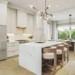 Modern open-concept kitchen interior at The Elms of Thornhill Woods, showcasing a marble-veined waterfall island with wooden barstools, minimalist white cabinetry, gold fixtures, and an adjacent bright dining area.
