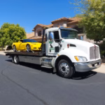 Freeway Towing & Storage flatbed tow truck transporting yellow Corvette in Mesa, AZ