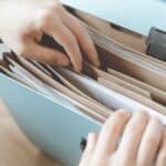書類整理をする手元の写真、終活のためのファイルと書類.