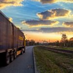 Commercial Trucking Business on the Road A commercial trucking business vehicle driving on a highway at sunset, representing the reliable support provided by total truck support services.