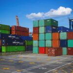 Shipping Containers at a Logistics Port Stacks of colorful shipping containers at a busy port, representing the logistics and supply chain essential for a commercial trucking business.