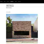 Contemporary building with a brick facade, minimalist design, rectangular form, and large black window.