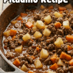 Close-up of a rustic pan featuring Mexican picadillo (ground beef, potato, and carrots in a red sauce).