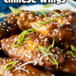 A close-up view of the baked Chinese Chicken Wings on a plate, highlighting the glossy glaze, toasted sesame seeds, and chopped green onions.