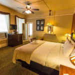 A cozy hotel room in Eureka Springs with a comfortable bed, vintage decor, and warm lighting.