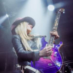 A vibrant female guitarist performing at the Eureka Springs Blues Festival, showcasing live music.