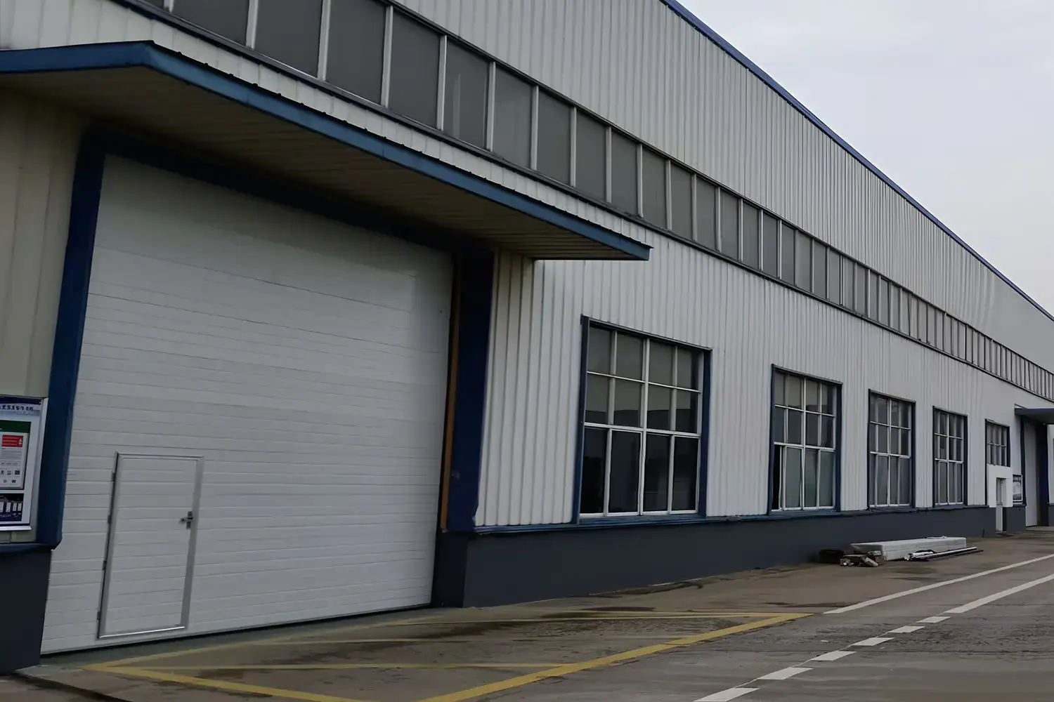 ANSI/DASMA certified industrial sectional door with a pedestrian pass door, ensuring safety, durability, and compliance for US commercial facilities.