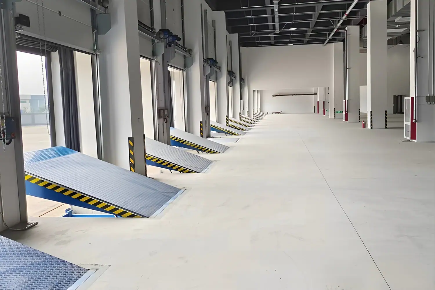 Row of heavy-duty industrial dock high doors integrated with hydraulic dock levelers in a modern logistics warehouse, engineered for 24/7 loading bay efficiency.