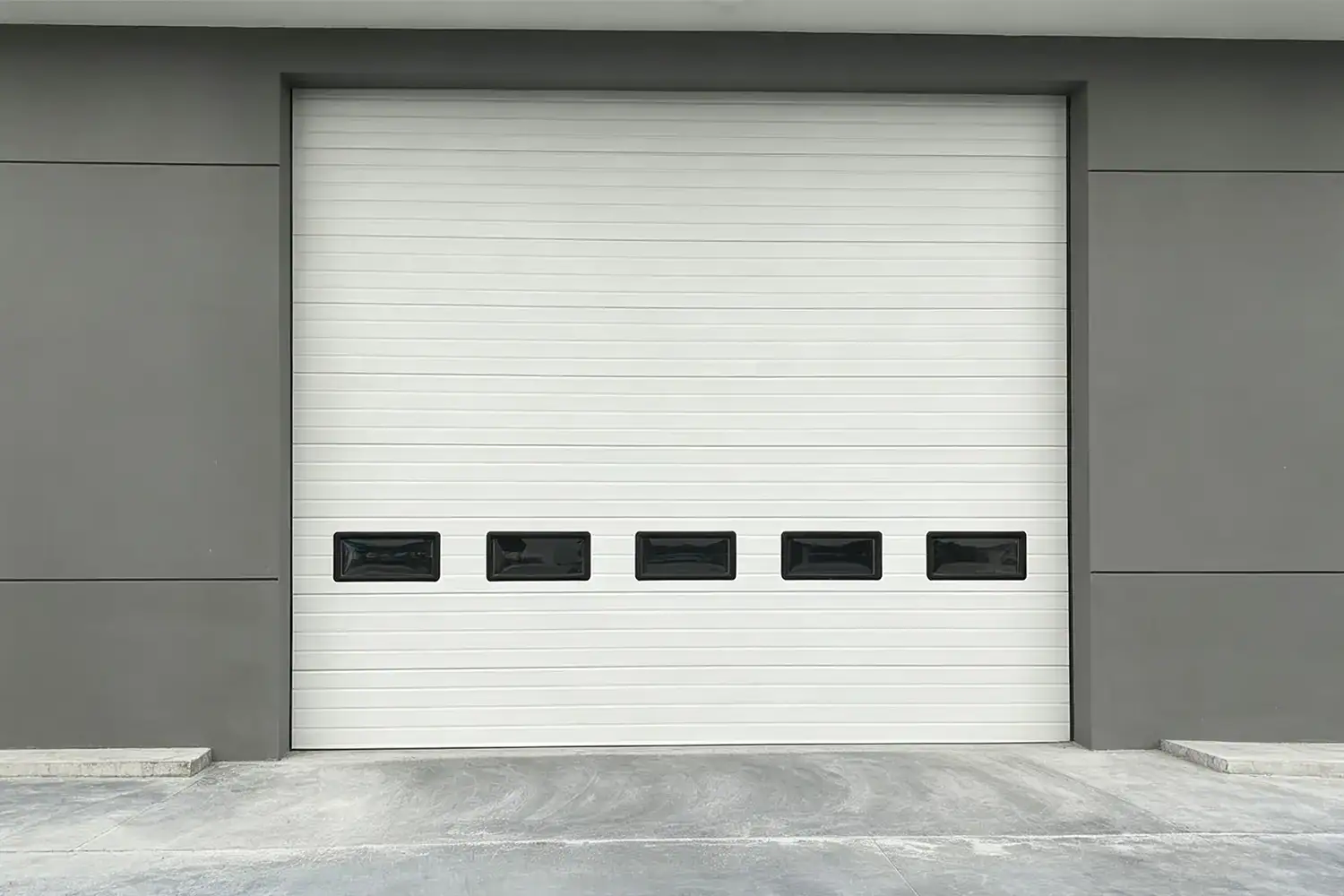 Industrial Sectional Overhead Door with Vision Windows Installed in Modern Factory Building