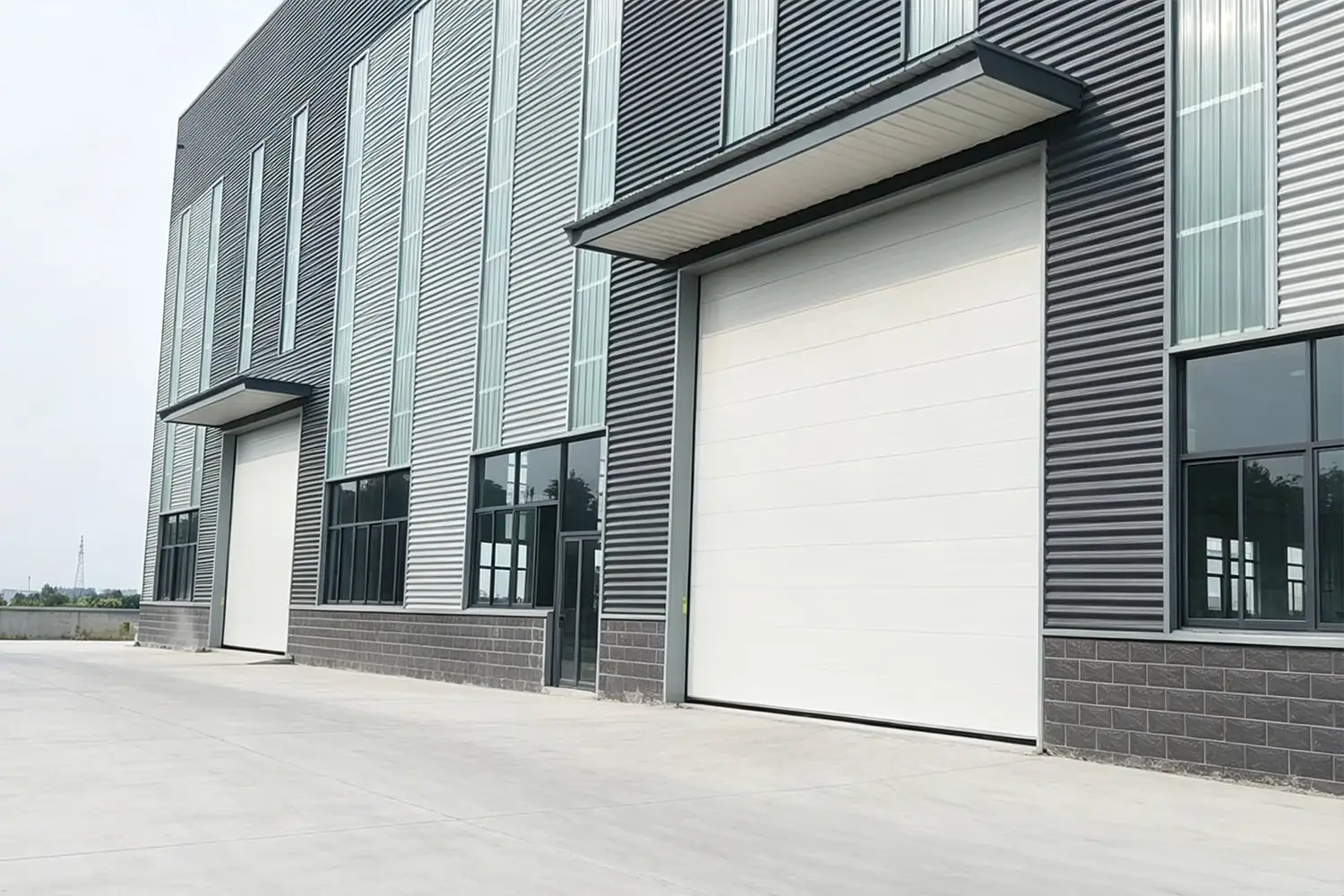 Modern Industrial Warehouse Exterior Facade Featuring Large White Sectional Overhead Doors and Canopies