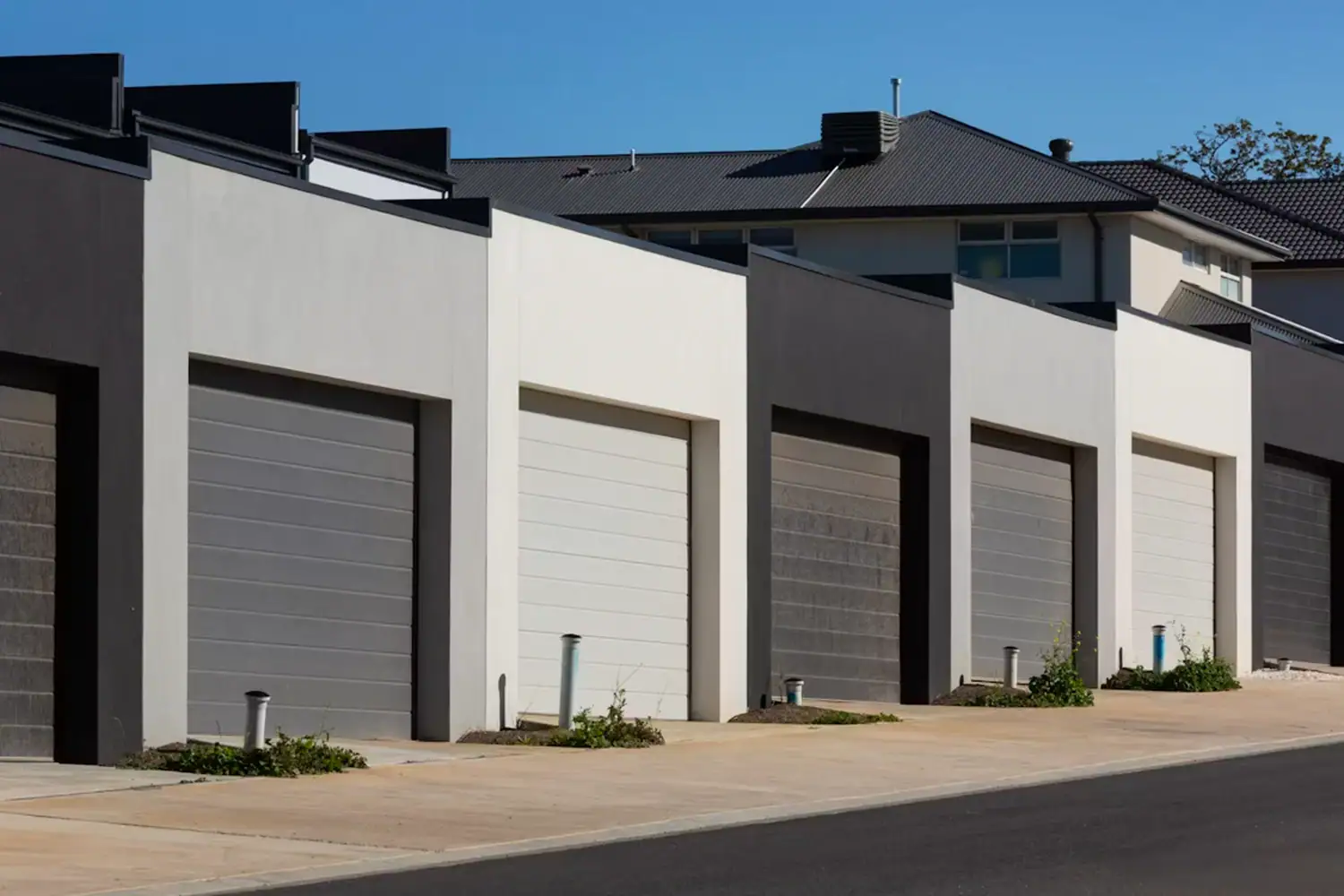 A row of heavy-duty commercial roll up doors installed in a multi-unit industrial facility. ABX OEM manufacturer offers various types of roll up doors for industrial projects, providing CE/ISO certified custom wholesale solutions.