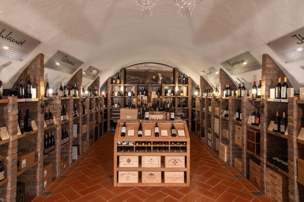 Weinlagerung in einer Keller- oder Weinkellerei, mit Flaschen und Kisten.