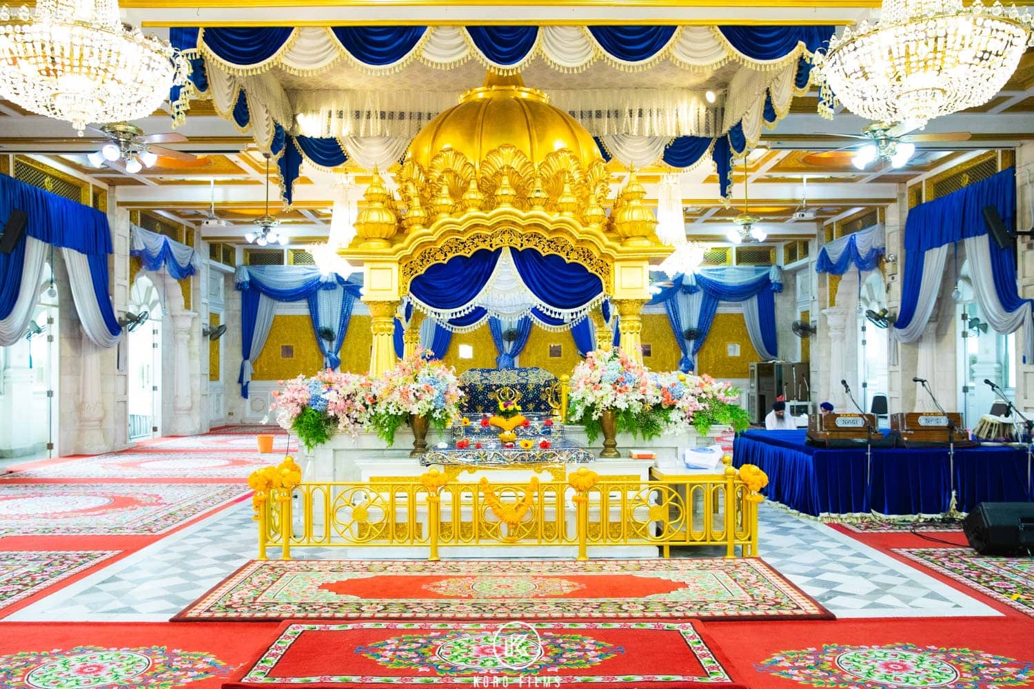 Darbar hall of Gurdwara Sri Guru Singh Sabha in Bangkok decorated for an Anand Karaj, with the palki of Guru Granth Sahib Ji