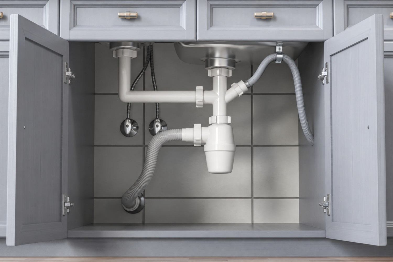 Dishwasher drain hose secured in a high loop under a kitchen sink