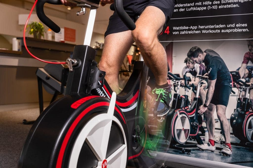 Hochintensive Indoor-Cycling-Training mit einem Mann auf einem stationären Fahrrad.
