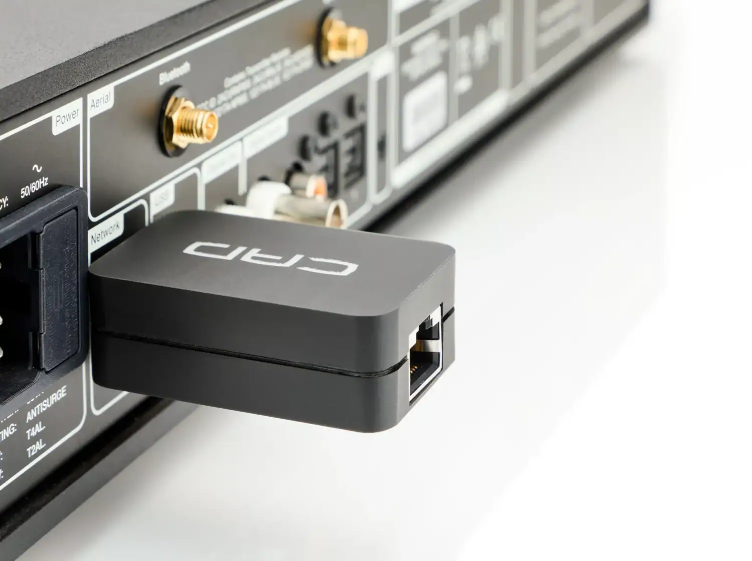 CAD Ethernet Control connexté à l'arrière d'un appareil Hi-fi avec le port RJ45 femelle visible