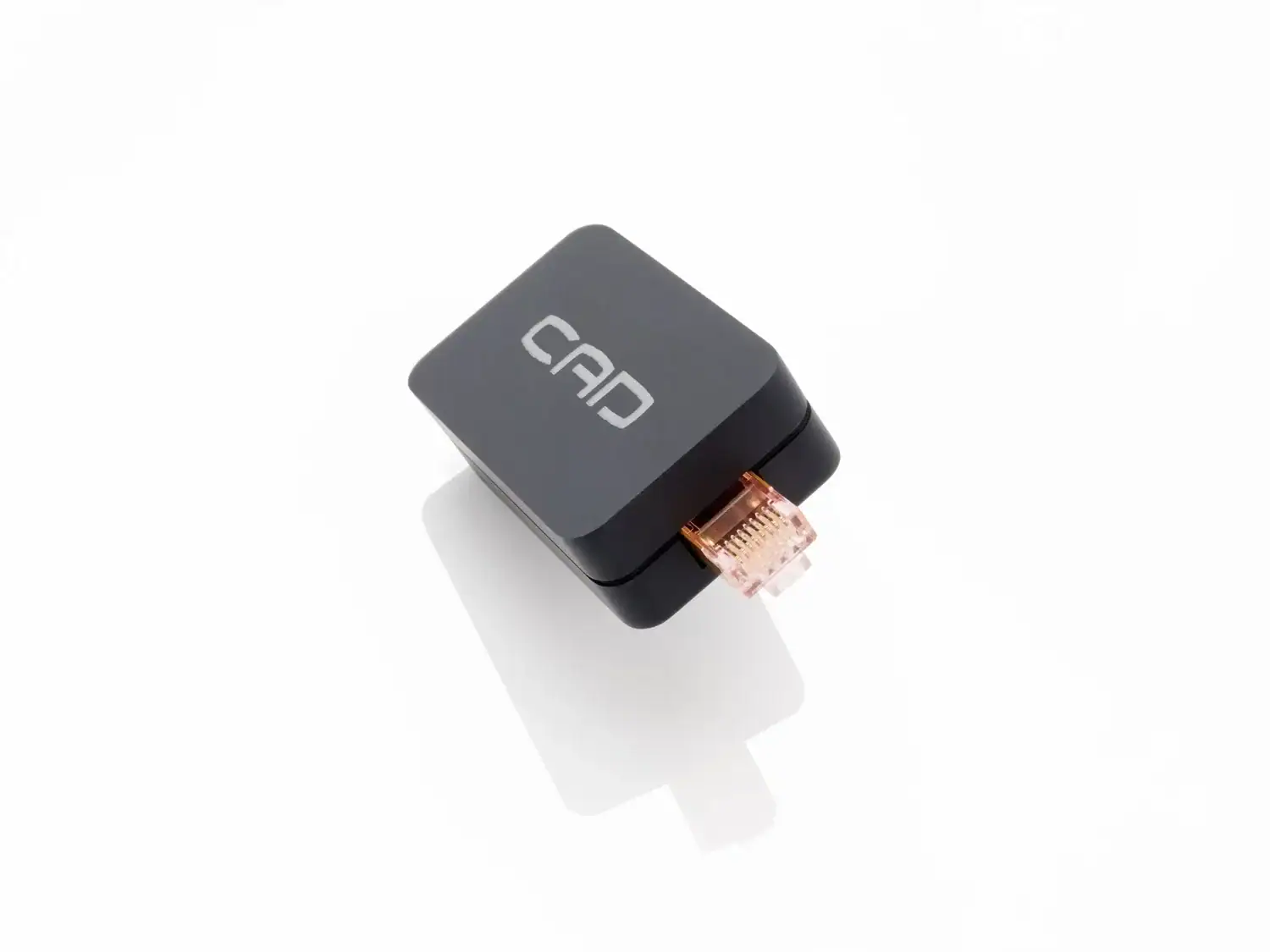 CAD Ethernet Control vu côté port RJ45 mâle avec son reflet sur un revêtement blanc