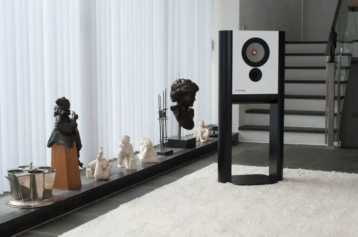 Grimm Audio Ls1v2 blanche en situation à côté d'une baie vitrée