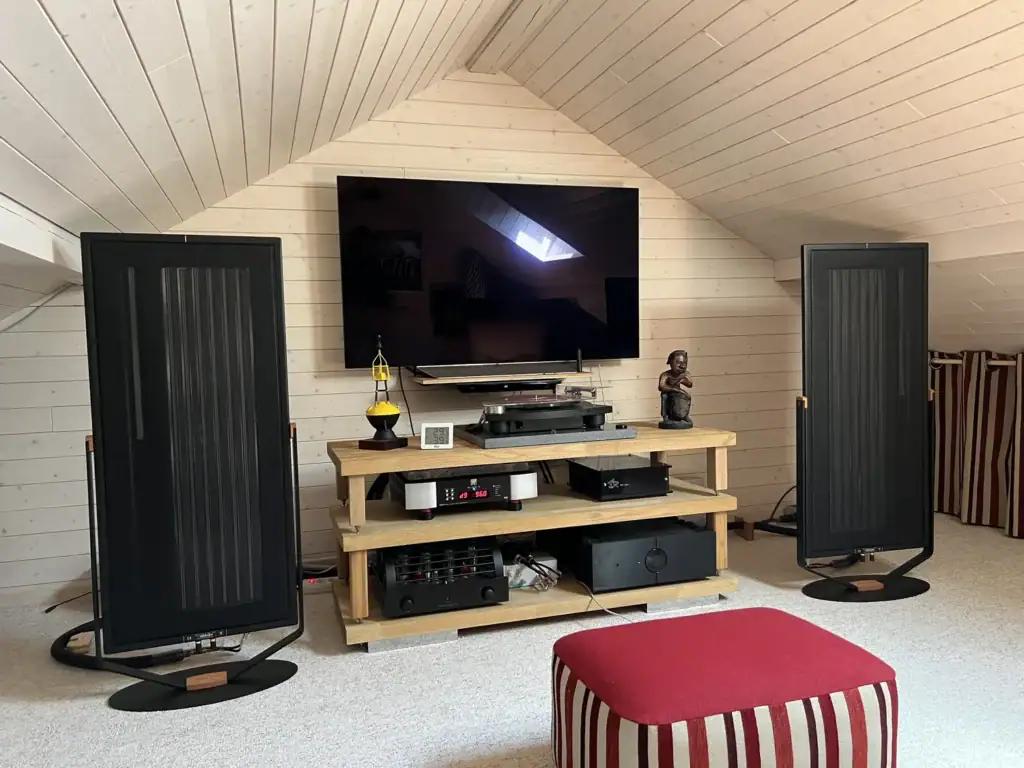 Paire de Diptyque Audio dp77 dans une pièce mansardée en bois avec un tapis gris au sol