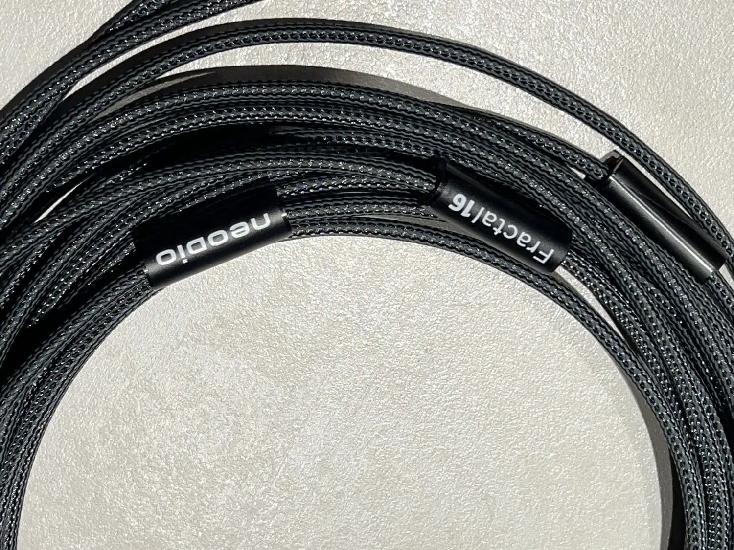Zoom sur les bagues des câbles haut-parleurs Neodio Fractal-L de 3 mètres sur fond clair