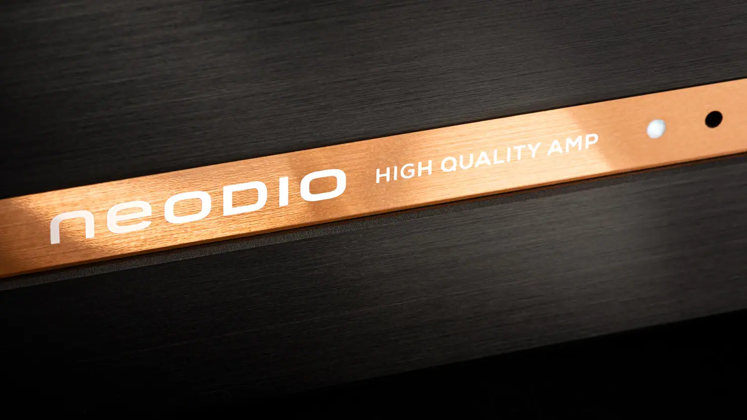 Zoom de la bande cuivrée de la face avant de l'amplificateur Neodio HQA