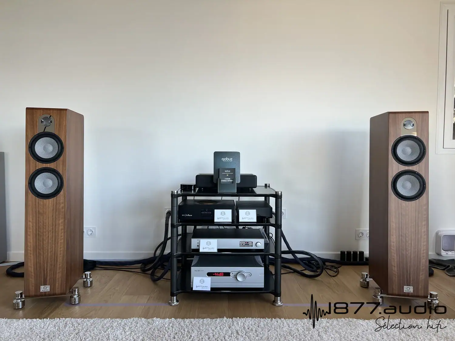 Marten Parker Trio en situation de part et d'autre d'un rack Hi-Fi avec des appareils électroniques