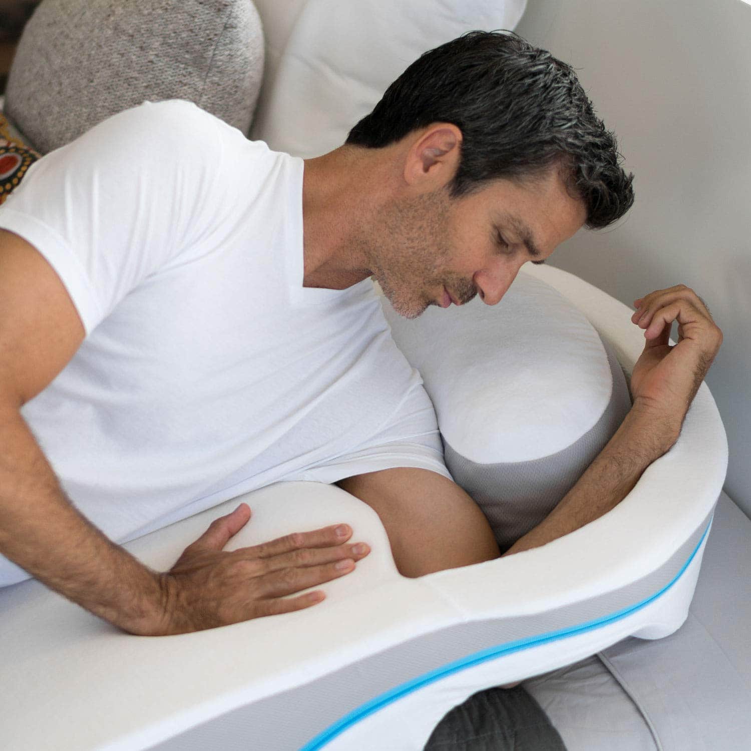 a man placing his arm into a MedCline shoulder relief pillow