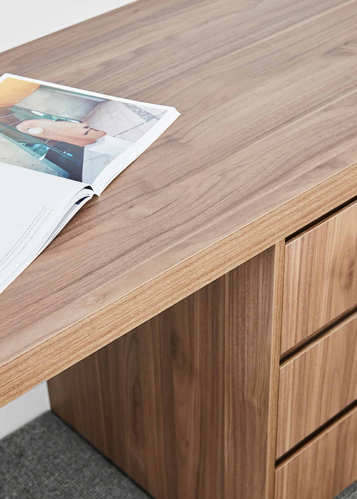 Close-up detail of a custom timber desk featuring integrated drawers and natural wood grain finishes.