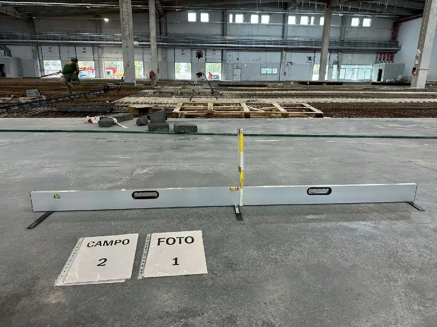 Test di planarità su pavimento industriale in fase di verifica, in grande logistica
