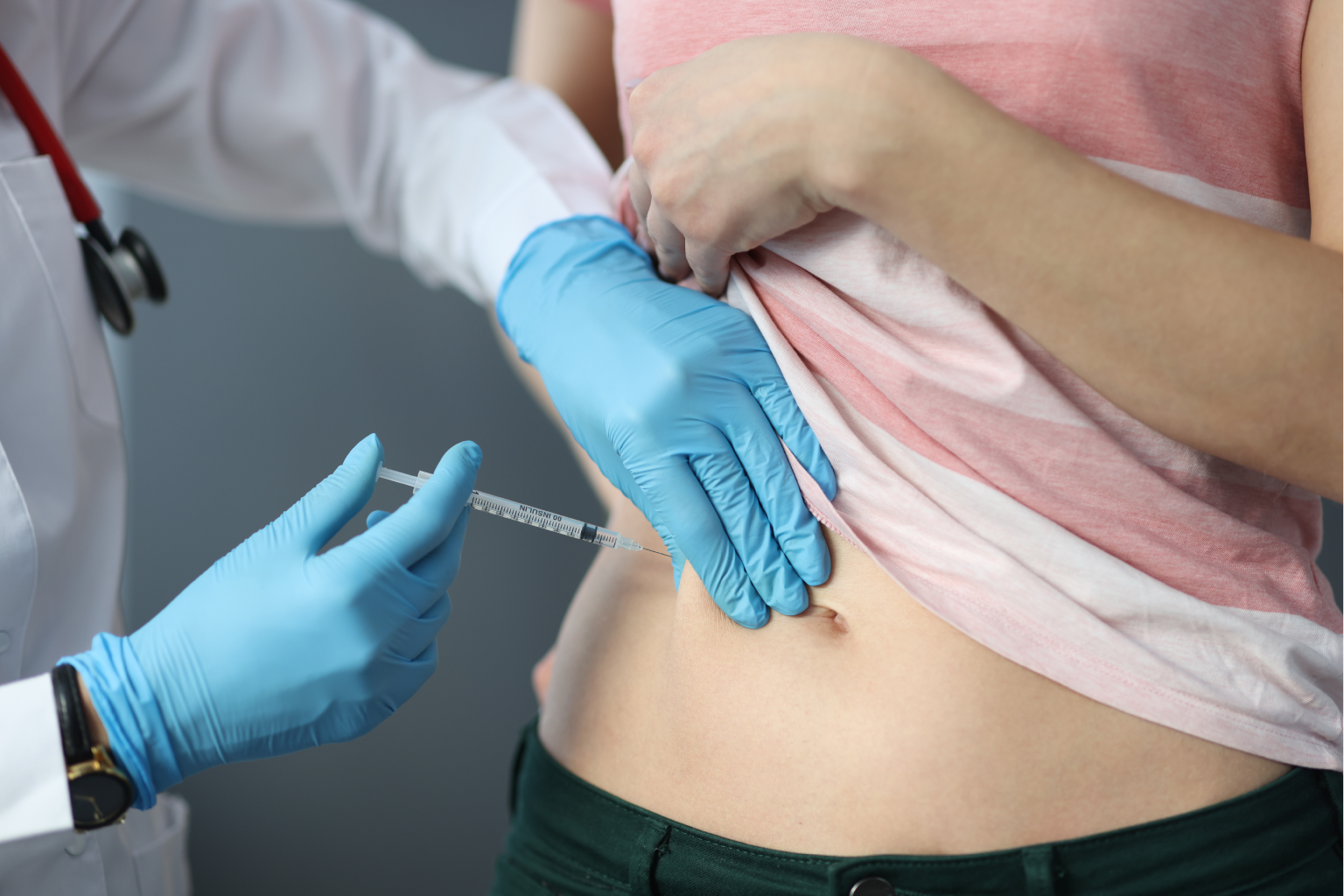 Doctor inserting mesolipo fat dissolving injection on patient’s stomach area