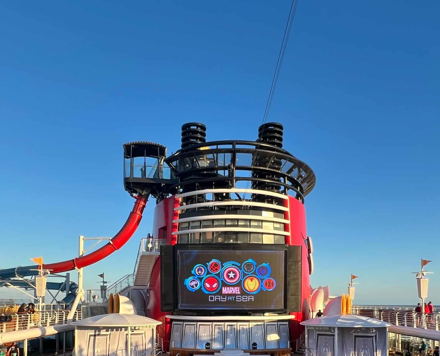 Viking Ocean cruise ship with Marvel Day at Sea event, outdoor deck, bright red water slide, and clear blue sky.