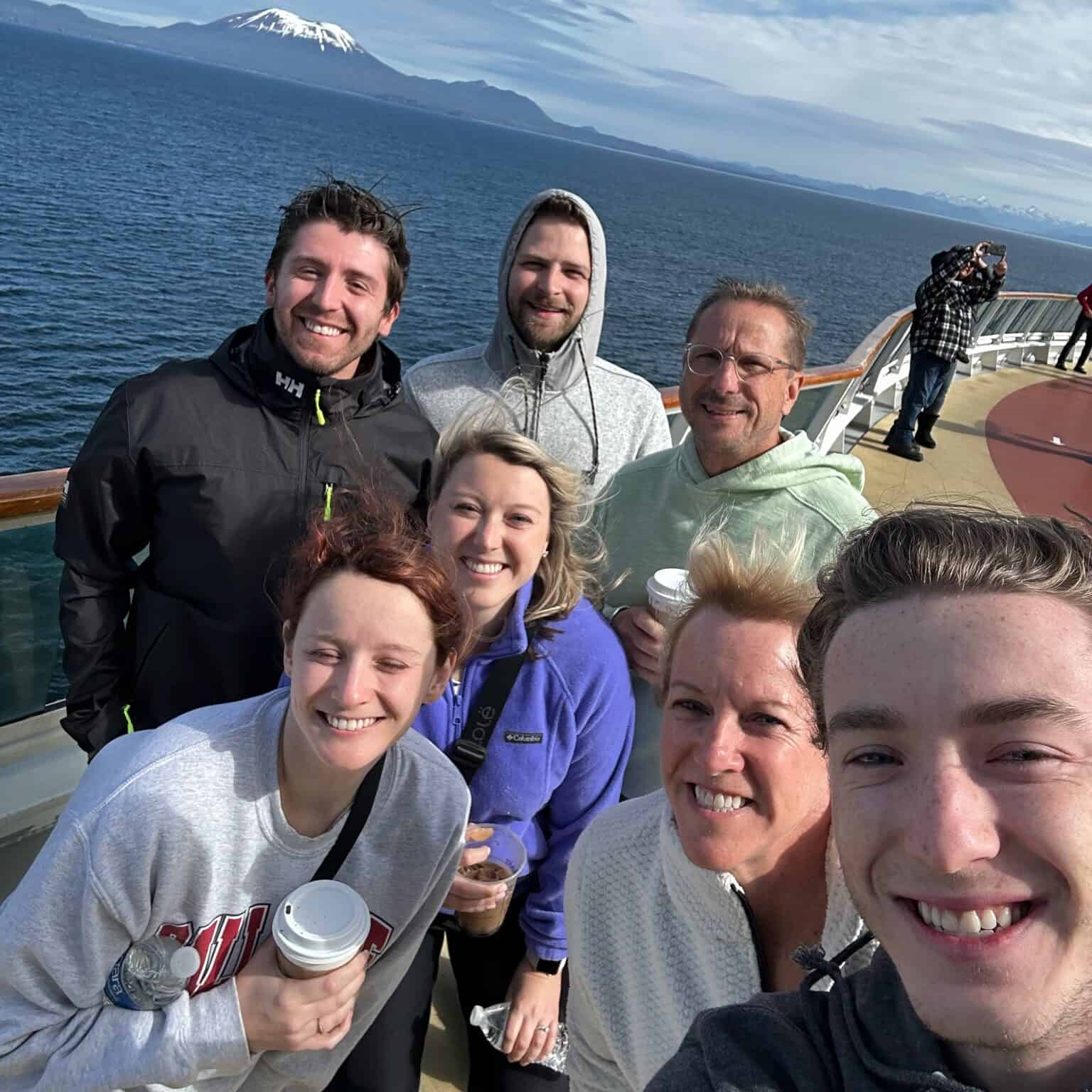 Family enjoying a scenic boat tour in Alaska with Mount Hood in the background.