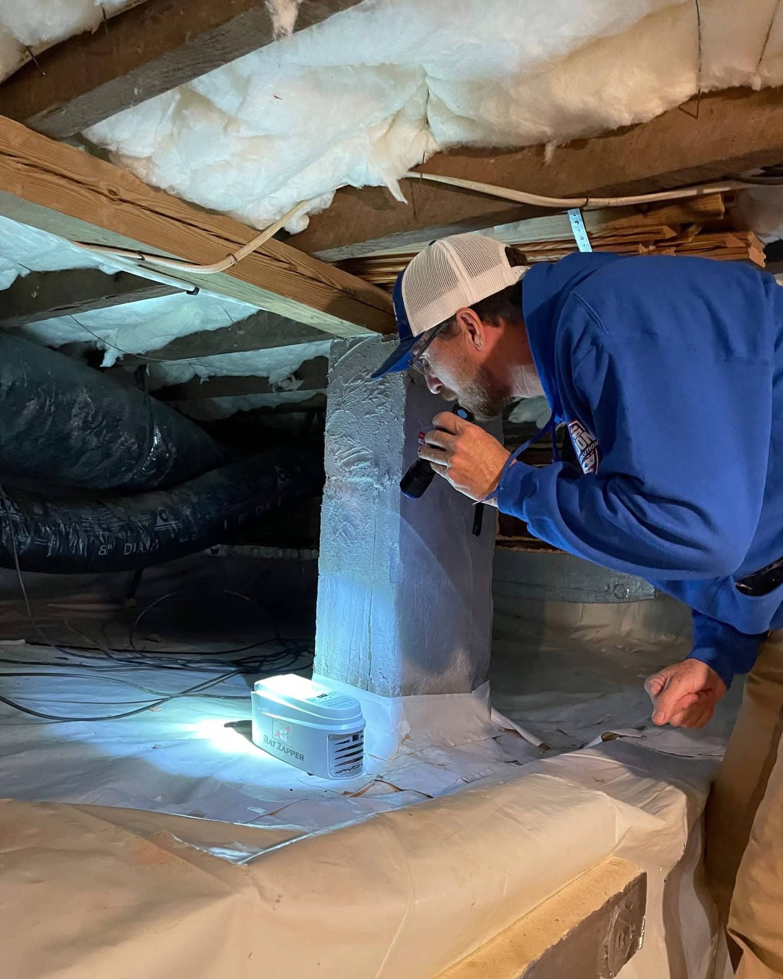 Freedom Wildlife Solutions & Pest Control technician inspecting a crawl space beneath a home for signs of rodents, checking for mouse and rat activity, entry points, and damage during a professional crawl space rodent inspection in Raleigh, NC.