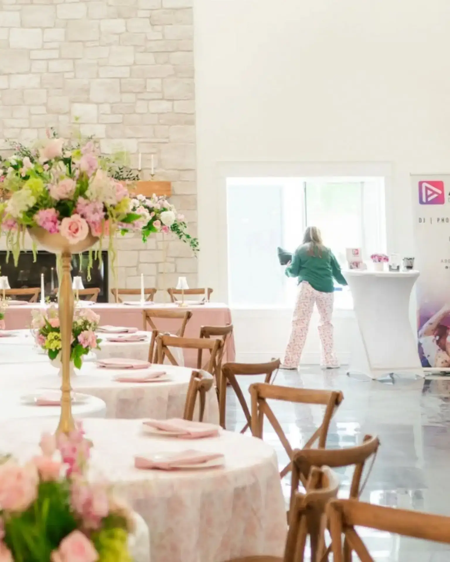 Reception hall set with pink floral centerpieces and cocktail tables at Romaine Valley Weddings & Events in Fenton, Missouri