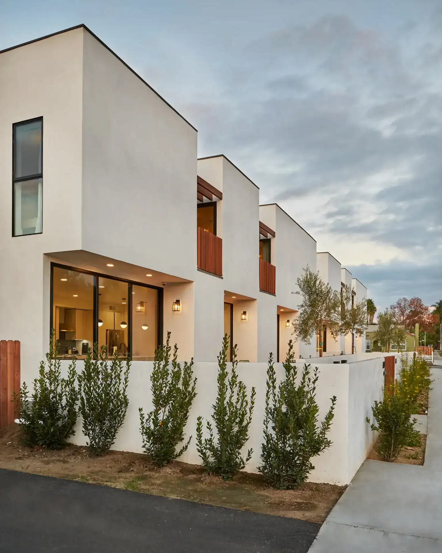 Modern minimalist white stucco residential building with clean geometric lines and flat roofs.