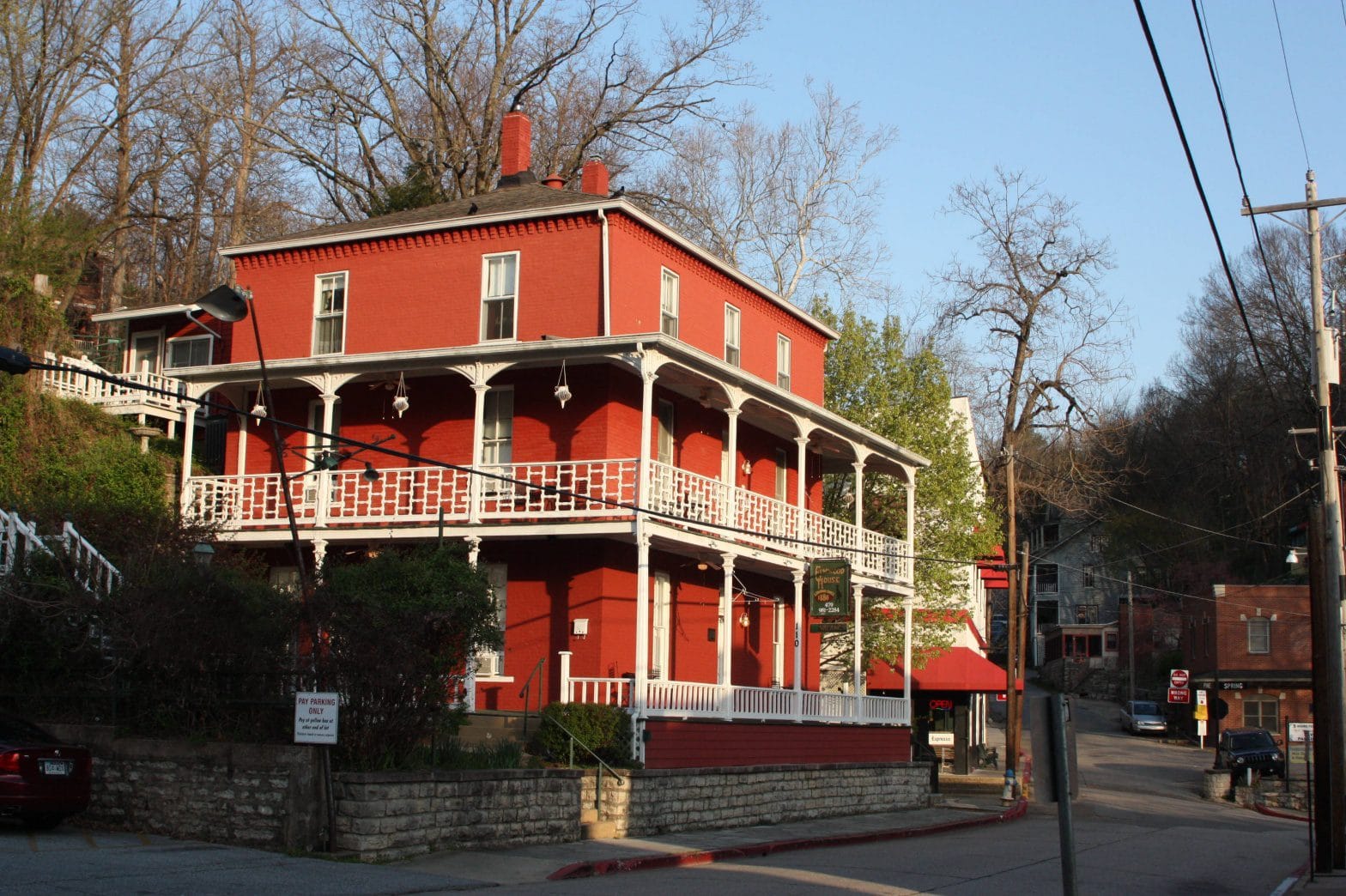 A red historic building with a wraparound porch in Eureka Springs, Arkansas.