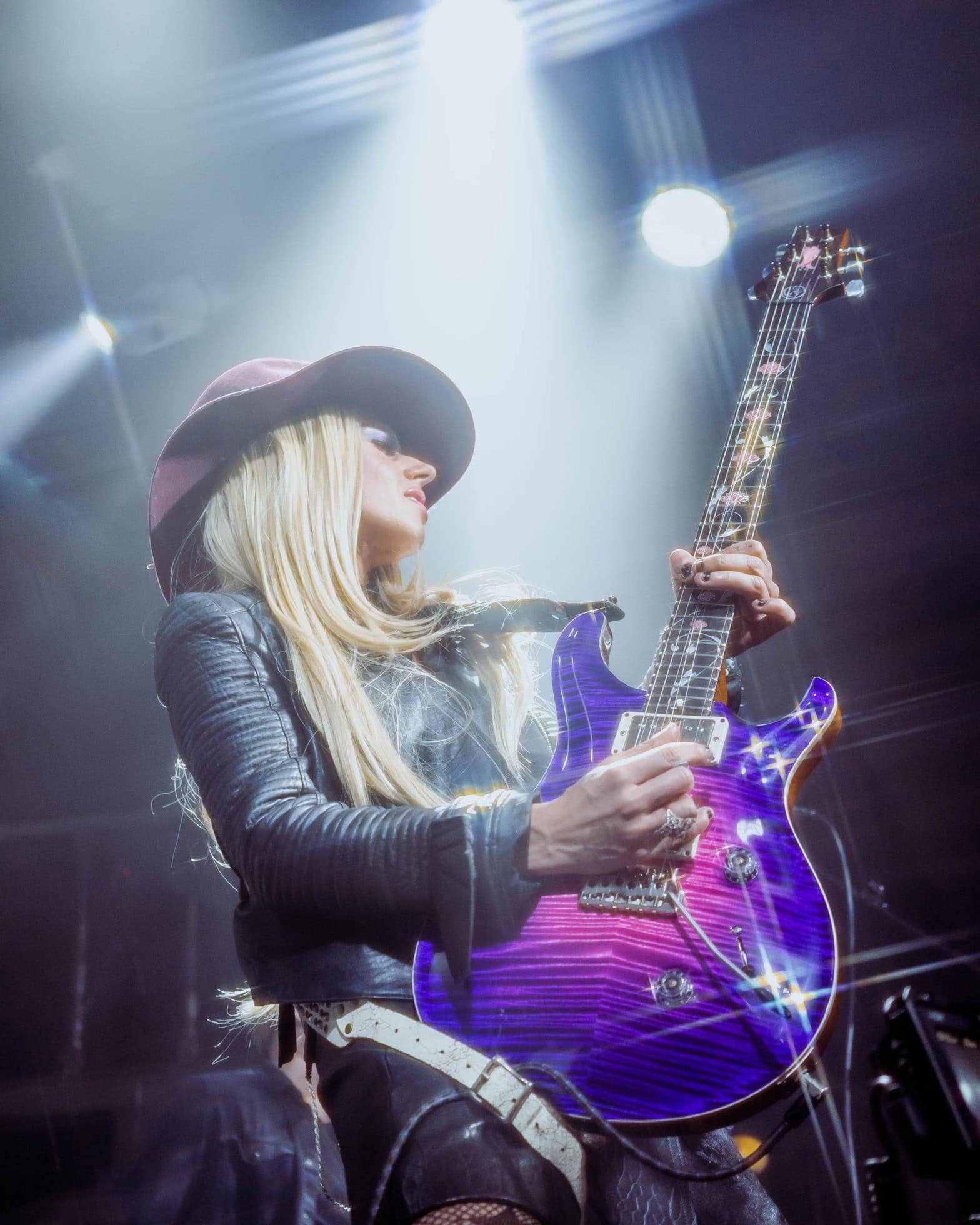 A vibrant female guitarist performing at the Eureka Springs Blues Festival, showcasing live music.