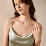Valenne silver moissanite clover necklace worn with matching bracelet in an elegant lifestyle setting