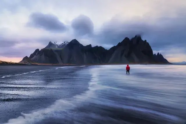 Stokksnes, en Islandia: playa negra con una figura de rojo. Foto de Antun