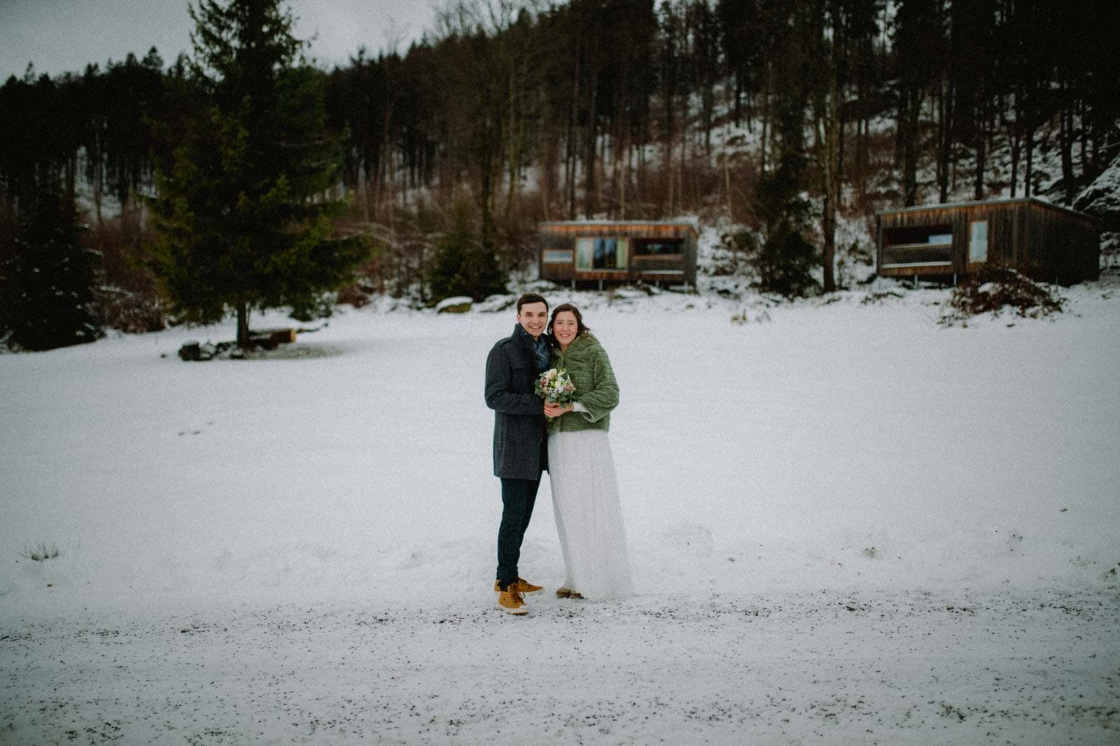 Brautpaar vor Holzbungalows