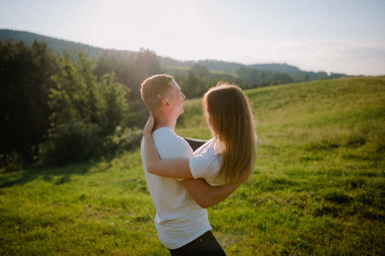 Mann trägt seine Freundin über Wiese