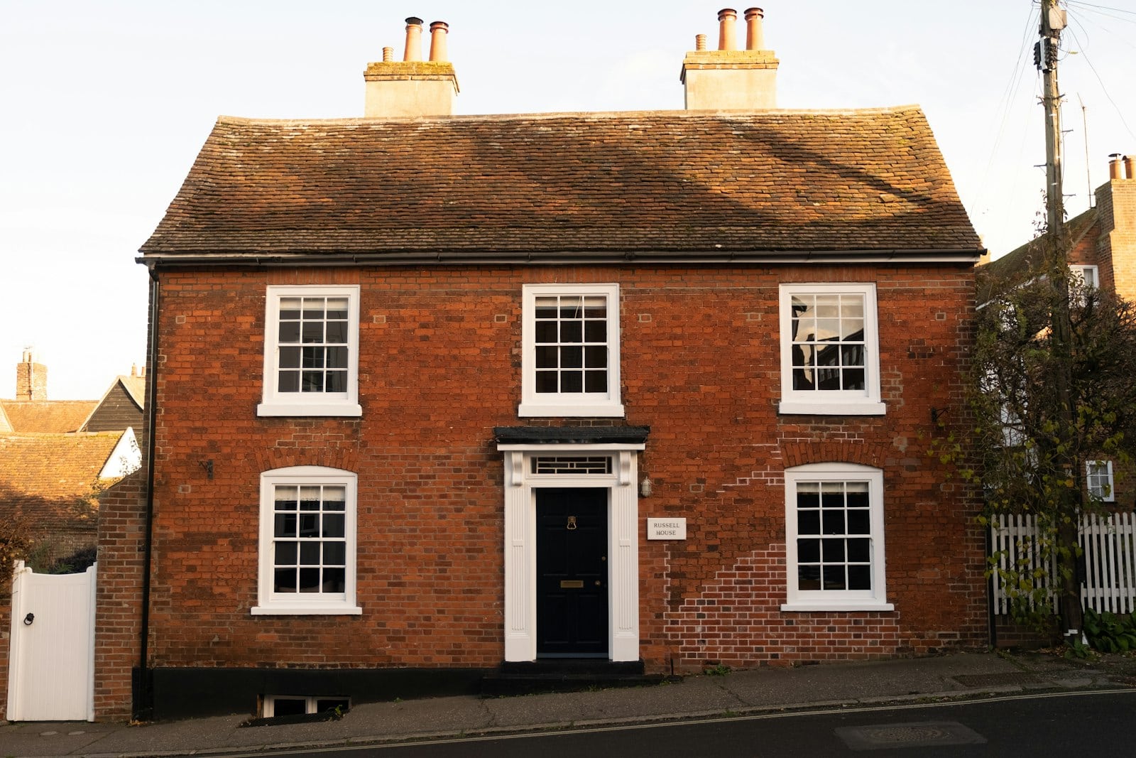 A traditional red brick English house with white-framed windows, representing a UK home for sale
