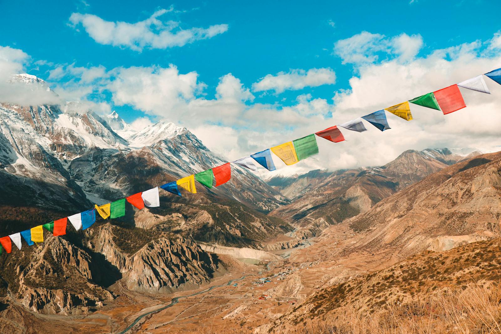 Vibrant prayer flags against the majestic Himalayas in Manang, Nepal.