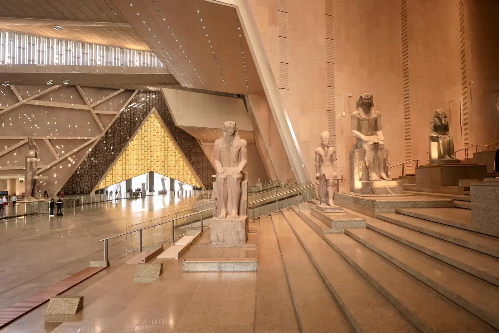 Ancient royal statues displayed along the Grand Staircase at GEM