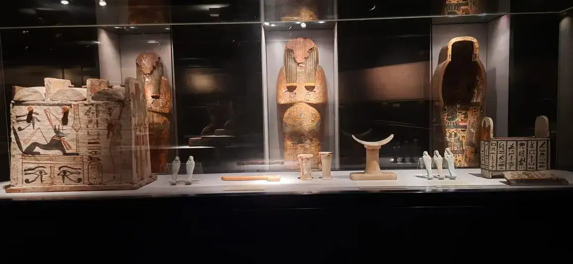 Ancient Egyptian funerary objects and coffin display in Luxor