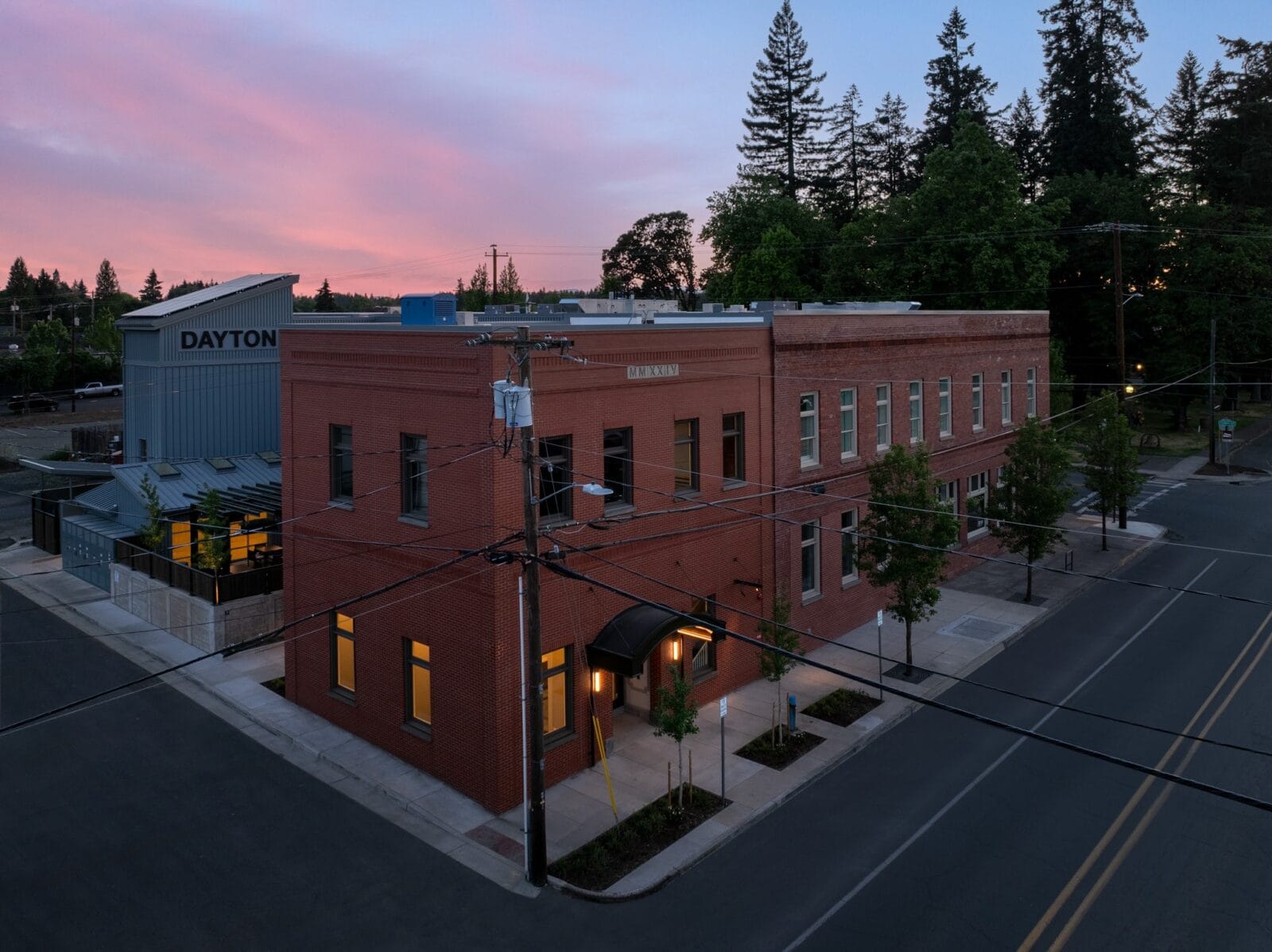The Inn at Dayton at dusk with soft evening light, warm interior glow, and a peaceful sky above
